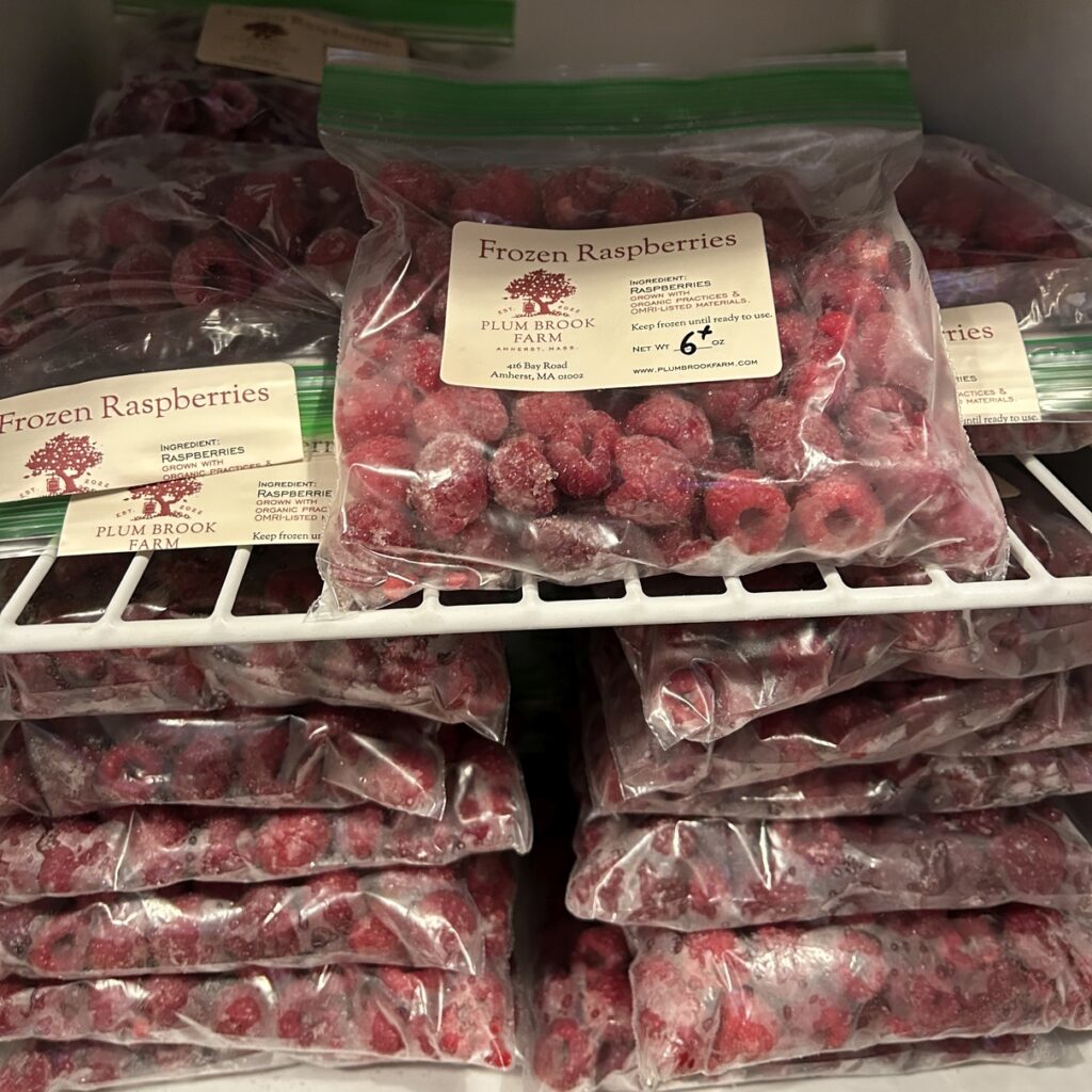 Bags of frozen Plum Brook Farm raspberries for sale in the farmstand freezer.